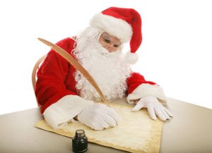 Santa writing on parchment with a large quill