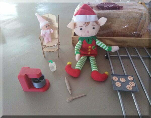 Christmas elf and baby elf beside a tray of biscuits on a tray