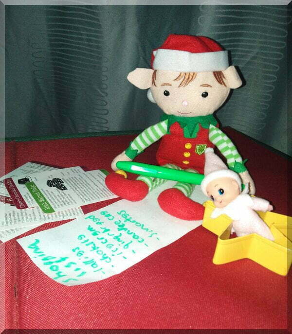 Christmas elf holding a green texta and writing a shopping list of sugary treats!