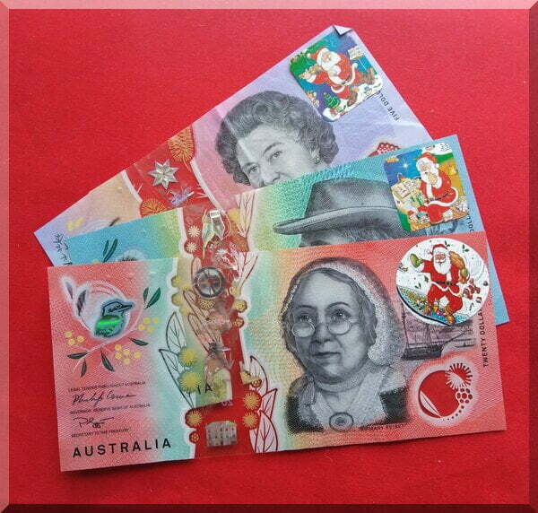 Australian currency with Santa stickers over the numbers as a fun way of gifting money at Christmas